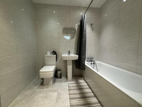 a bathroom with a toilet and a sink and a tub at Beautiful 1-Bed Apartment in Walton on the Naze in Walton-on-the-Naze