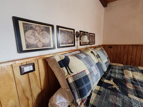a bedroom with a bed with a blanket and pictures on the wall at Finca Chuchiyá cabañas Tecpan in Tecpán Guatemala