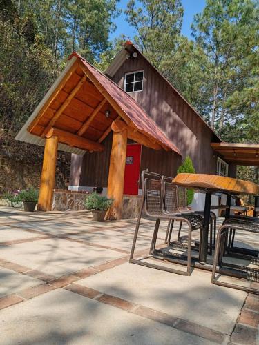 a barn with a table and chairs in front of it at Finca Chuchiyá cabañas Tecpan in Tecpán Guatemala
