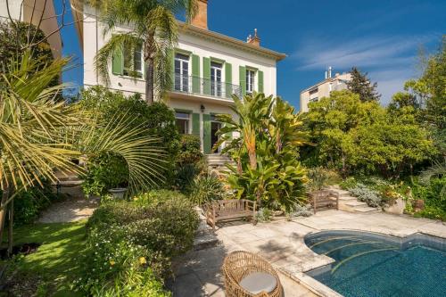 une maison avec une piscine en face d'une cour dans l'établissement Cannes centre maison bourgeoise, à Cannes