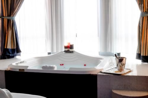 eine große Badewanne in einem Zimmer mit Fenster in der Unterkunft Hotel Michelangelo Palace & SPA in Terni