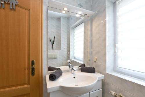 ein weißes Badezimmer mit einem Waschbecken und einem Spiegel in der Unterkunft Bungalow Seestern - b47691 in Malchow