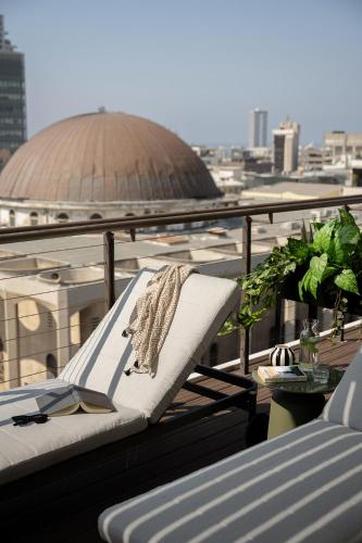 a towel is sitting on a chair on a balcony at Mr. Rothschild by TLV2GO in Tel Aviv