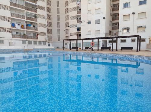 una gran piscina frente a algunos edificios en Apartamentos Bonaire 1ª Linea Wifi Solo Familias Serviplaya, en Gandía