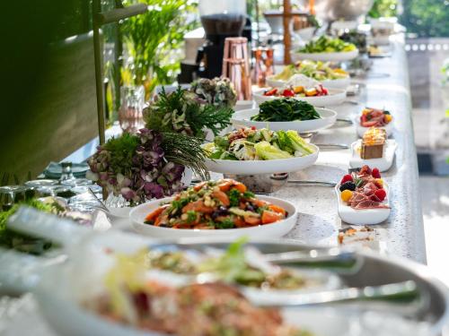 a buffet line of plates of food on a table at The Dolli at Acropolis, A Hotel to Live in Athens