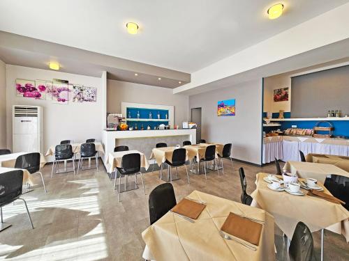 a restaurant with tables and chairs and a counter at Hotel l'Approdo in Porto Azzurro