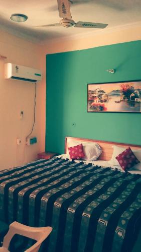 a bedroom with a bed with a blue wall at AR Resort Gauchar in Chamoli