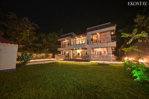 una casa grande con patio por la noche en EKOSTAY Gold - Amara Villa en Alibaug