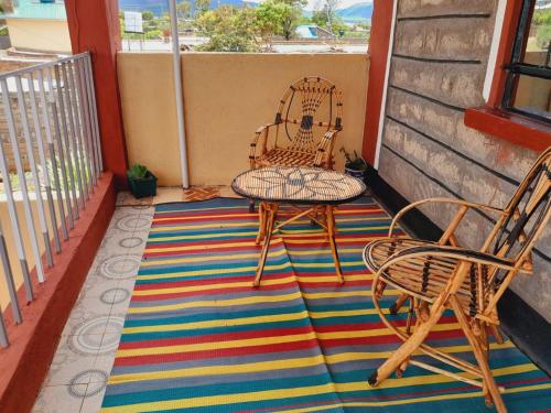 a patio with two chairs and a table on a rug at Hotfoot Homestays in Isiolo