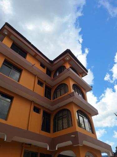 un edificio amarillo con un cielo en el fondo en King Palace Hotel, en Dar es Salaam
