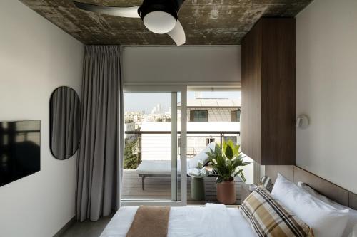 a bedroom with a bed and a balcony at Mr. Rothschild by TLV2GO in Tel Aviv