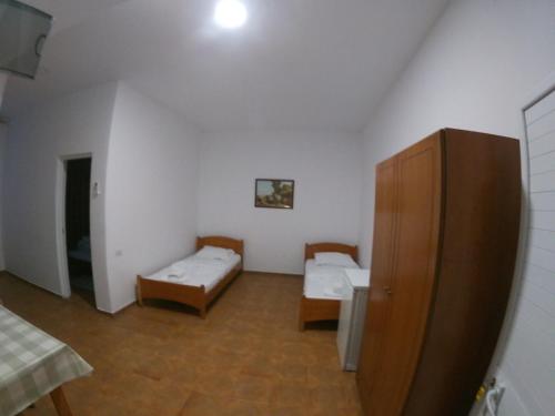 a room with two beds and a cabinet at Hostel Casa Mia SR in Sarandë