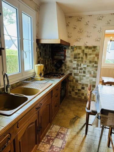 une cuisine avec un évier et un plan de travail dans l'établissement Maison familiale, jardin clos, proche Menhirs et plage, à Carnac