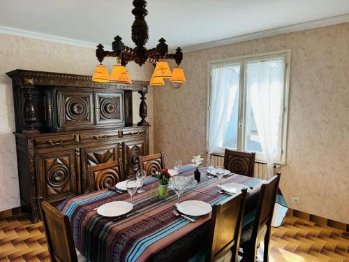 une salle à manger avec une table et un grand lit dans l'établissement Maison familiale, jardin clos, proche Menhirs et plage, à Carnac