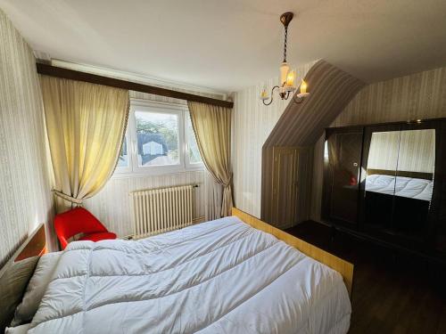 une chambre avec un grand lit et une fenêtre dans l'établissement Maison familiale, jardin clos, proche Menhirs et plage, à Carnac