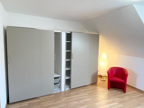 a room with a red chair and a closet at Ferienwohnungen Grimma 6 in Grimma