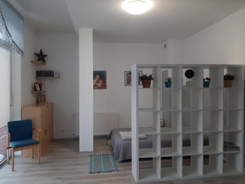 a bedroom with a white book shelf and a bed at STUDIO ZAMKOWA OLECKO in Olecko