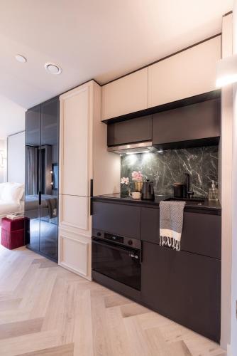 a kitchen with black cabinets and a stove at The Brondesbury by Nestor in London