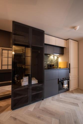 a kitchen with black cabinets and a counter top at The Brondesbury by Nestor in London