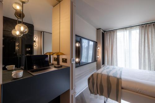 a bedroom with a bed and a desk with a computer at The Brondesbury by Nestor in London