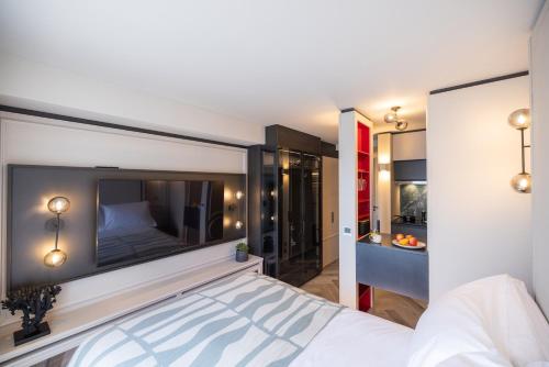 a bedroom with a large white bed and a bathroom at The Brondesbury by Nestor in London