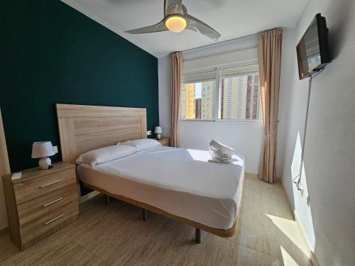 una camera con letto e ventilatore a soffitto di Apartamento Benimar Beach a Benidorm