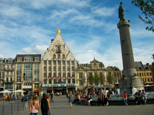 a group of people standing around a fountain in front of a building at Private Room & Spa avec jacuzzi privatif in Lille