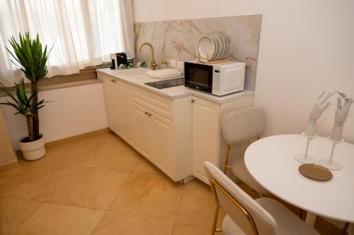 una piccola cucina con tavolo e forno a microonde di Home Sicilia24 a Catania