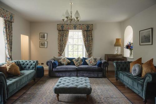 a living room with blue couches and a window at Shortflatt Tower in Longwitton