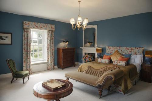 a bedroom with blue walls and a bed and a chair at Shortflatt Tower in Longwitton