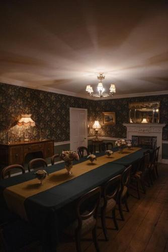 a dining room with a long table and chairs at Shortflatt Tower in Longwitton