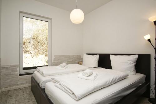 ミデルハーゲンにあるnaturnah, mit Terrasse, Garten und Meerblick - Ferienwohnung auf dem Teschenbergのタオルが敷かれたベッドが2つある寝室