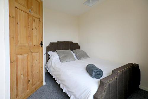 a bedroom with a large bed with a wooden door at Lovely 3 bedroom house with free parking & garden in Norwich