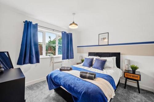 a bedroom with a large bed with blue curtains at Beautiful Lincoln Abode - Sleeps 6 - Parking in Lincoln