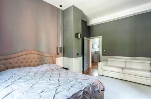 ein Schlafzimmer mit einem großen Bett und einem Sofa in der Unterkunft VaticanHome51 in Rom