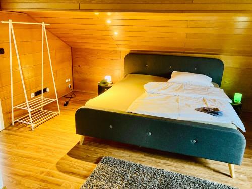 um quarto com uma cama num quarto com paredes de madeira em Ü Villa Resturlaub OG em Hirschaid