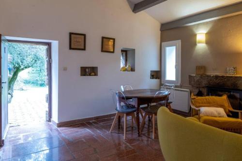 un salon avec une table et des chaises et une cheminée dans l'établissement CASA VIGNOLA, à Fozzano