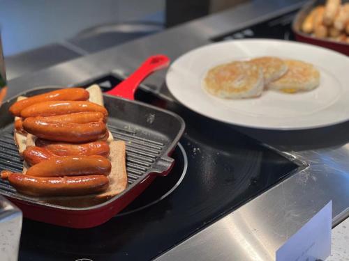 a grill with a plate of hot dogs and bread at Hilton Garden Inn Kunming Dianchi in Kunming