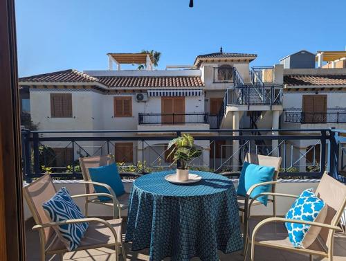 einen Tisch und Stühle auf einem Balkon mit Blick auf ein Gebäude in der Unterkunft Sunny days apartment in Playas de Vera