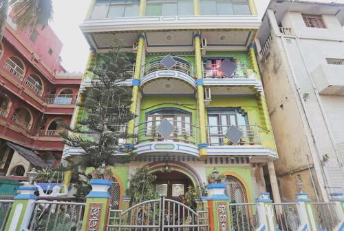 a colorful building with a tree in front of it at Hotel Ashray Near Golden Beach Luxury Stay in Puri