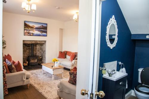 een woonkamer met blauwe muren en een open haard bij Luxury Scottish Hot Tub Getaway in Gatehouse of Fleet