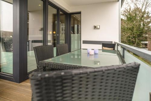 a glass table and chairs on a balcony at Baltic House Sandburg in Timmendorfer Strand