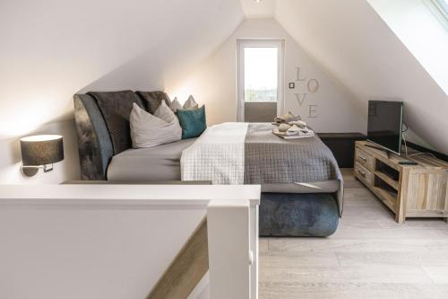 ein weißes Schlafzimmer mit einem Bett und einem Sofa in der Unterkunft Baltic House Penthousewohnung Seestern in Timmendorfer Strand