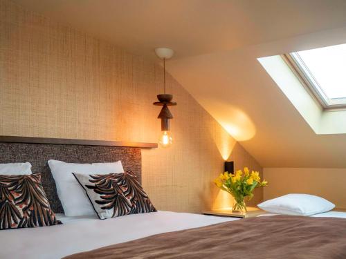 um quarto com uma cama e uma clarabóia em Mercure St Malo Front de Mer em Saint Malo