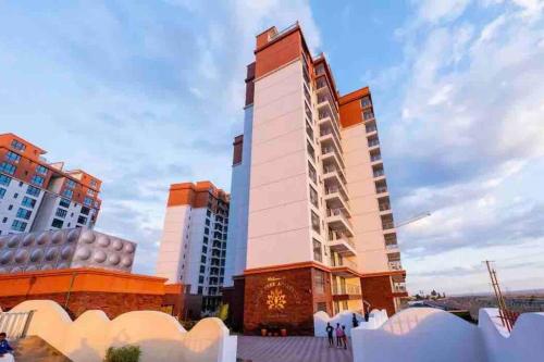 un edificio alto con gente parada frente a él en Abantu Parkview 2BR Suite near JKIA SGR with Pool Gym Eatery, en Nairobi