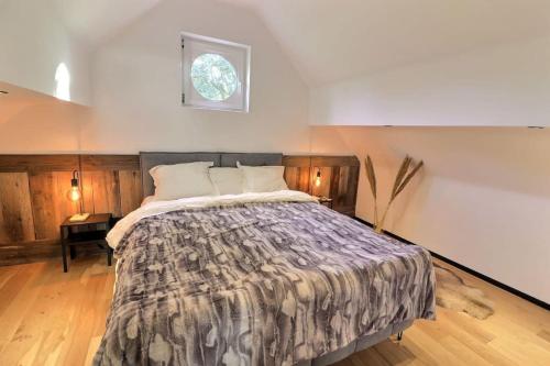 a bedroom with a bed and a window on the wall at Le cosy Cottage du chêne in Lasne