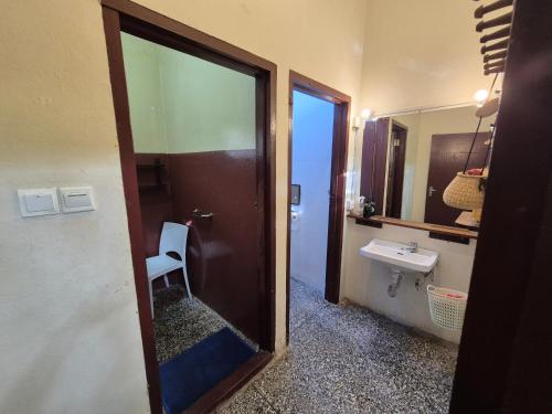 a bathroom with a toilet and a sink and a mirror at Hechtech House in Accra