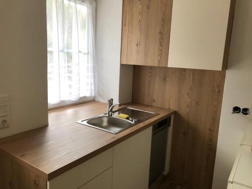 - une cuisine avec un évier et un comptoir en bois dans l'établissement Ferienhaus Holzer, à Mönichwald