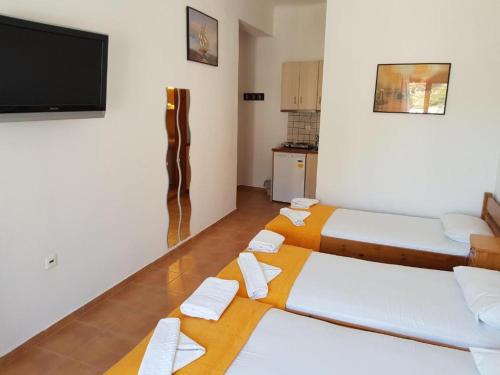 een kamer met 2 bedden en een flatscreen-tv bij Lydia Mare in Agios Kirykos