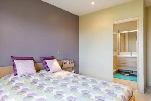1 dormitorio con 1 cama grande con almohadas moradas en Grande Maison à 15mn de Lyon centre en voiture, en Corbas